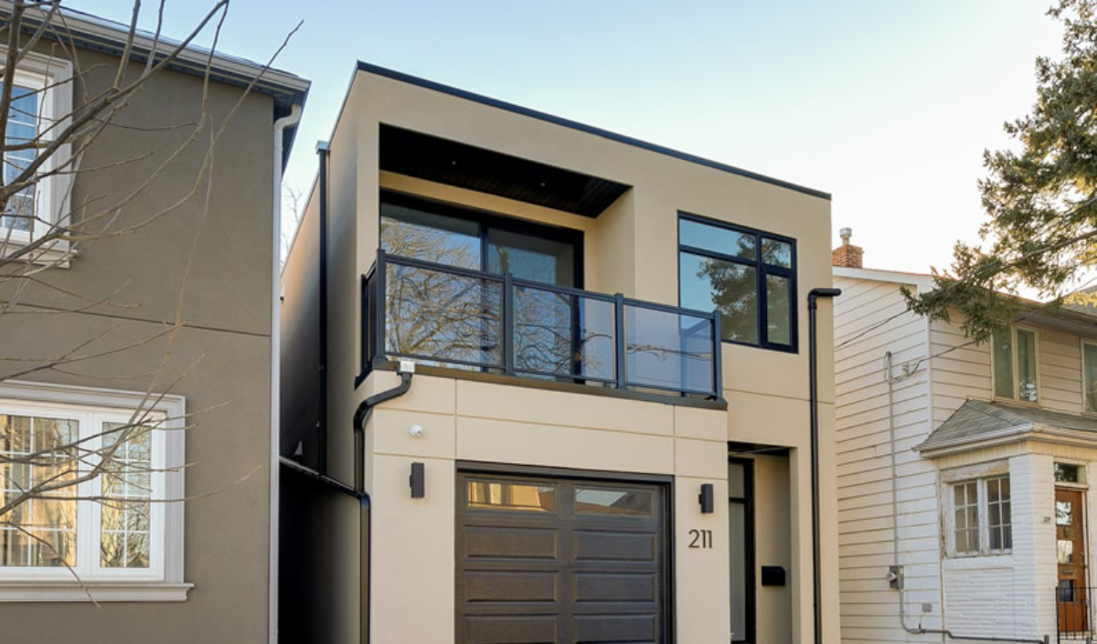 Modern two-story house with beige and black exterior, large windows, a balcony above the garage, and the number 211 displayed by the main entrance.