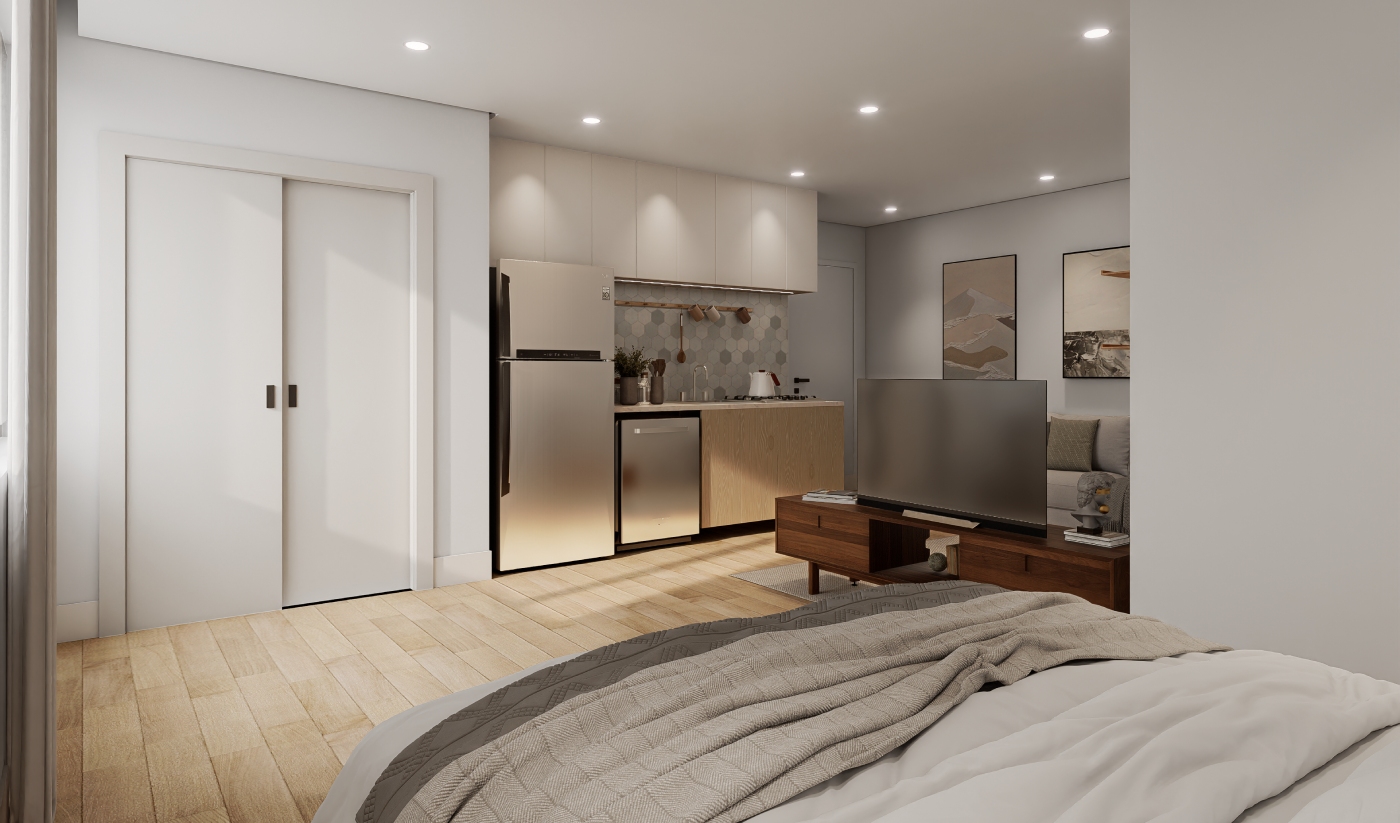 Modern studio apartment with a bed, TV, small kitchen, wooden floors, and minimalist decor featuring framed art and neutral colors.