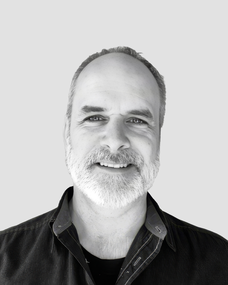 Headshot of a middle-aged man with a graying beard, smiling at the camera.